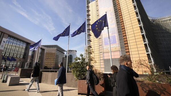 Люди проходят мимо штаб-квартиры ЕС в Брюсселе