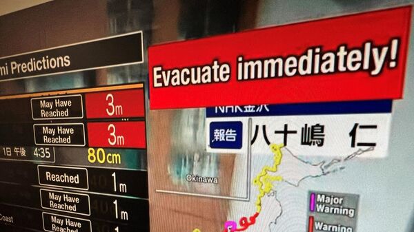 Экран прямой трансляции канала NHK World, призывающего людей эвакуироваться после серии сильных землетрясений, произошедших в центральной Японии. 1 января 2024