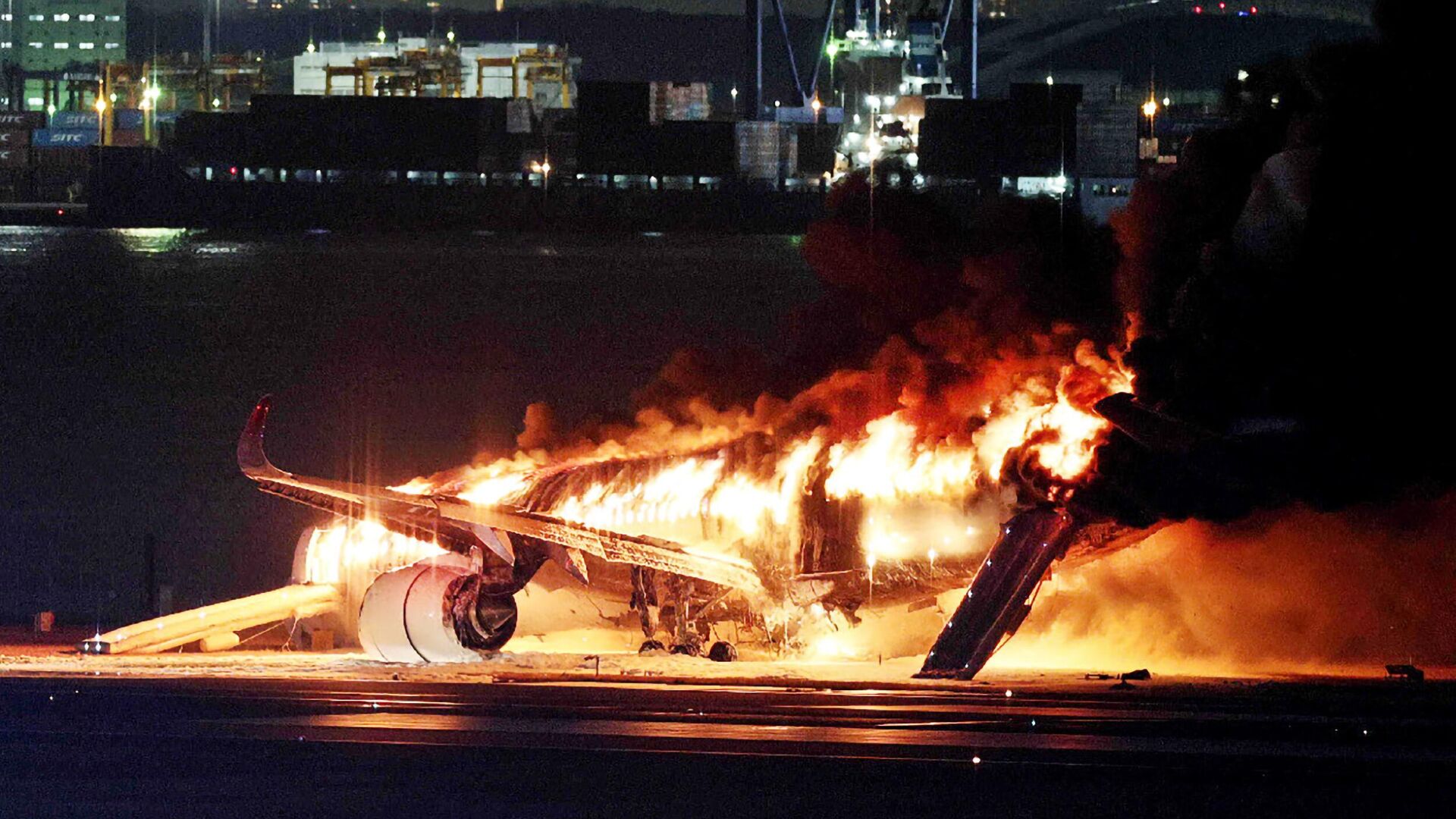 Горящий самолет Japan Airlines на взлетно-посадочной полосе токийского аэропорта Ханэда - РИА Новости, 1920, 02.01.2024