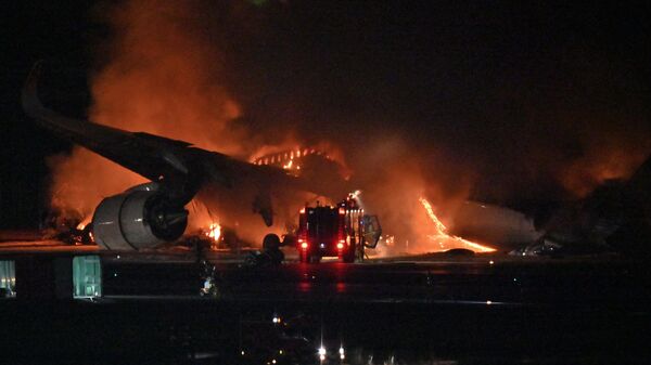 Пожар на месте столкновения двух самолетов в аэропорту Ханэда в Токио