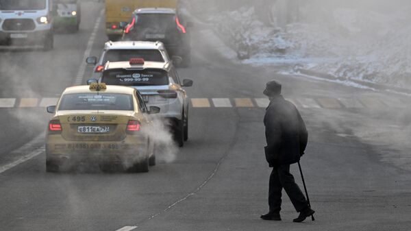 Мужчина переходит дорогу в морозный день на улице в Москве