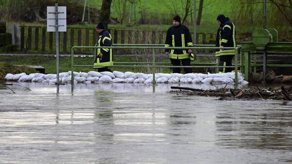 Сотрудники Федерального агентства технической помощи Германии проверяют уровень воды в реке