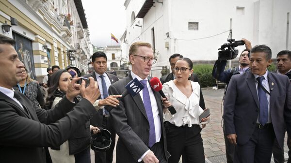 Посол США в Эквадоре Майкл Дж. Фицпатрик (в центре) беседует с прессой, покидая президентский дворец Каронделет в Кито
