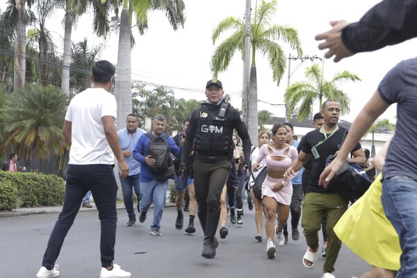Полиция эвакуирует сотрудников общественного телеканала TC Television после того, как группа вооруженных людей ворвалась на съемочную площадку во время прямого эфира в Гуаякиле, Эквадор