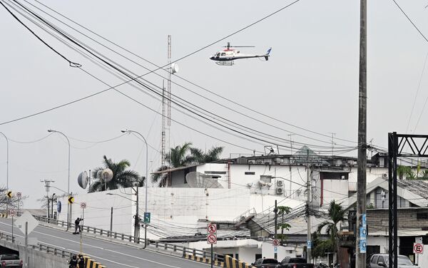Вертолет эквадорской полиции пролетает над зданием телеканала TC Television после того, как неизвестные вооруженные люди ворвались на съемочную площадку во время прямого эфира в Гуаякиле, Эквадор