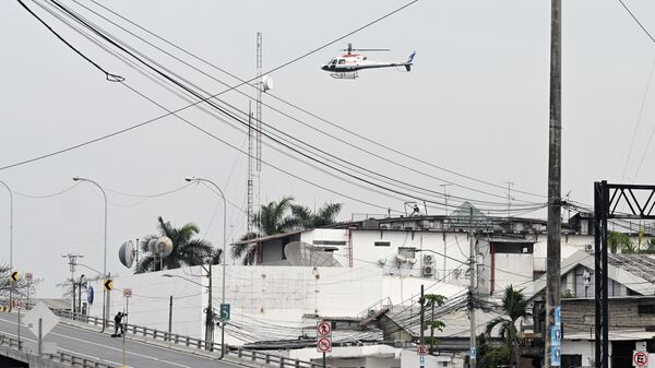 Вертолет эквадорской полиции пролетает над зданием телеканала TC Television после того, как неизвестные вооруженные люди ворвались на съемочную площадку во время прямого эфира в Гуаякиле, Эквадор