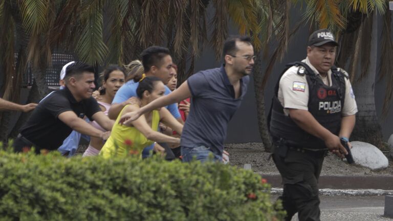 Полиция эвакуирует сотрудников общественного телеканала TC Television после того, как группа вооруженных людей ворвалась на съемочную площадку во время прямого эфира в Гуаякиле, Эквадор
