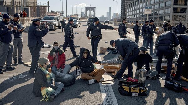 Полицейские задерживают участников протеста, блокирующих Бруклинский мост в Нью-Йорке. 8 января 2024