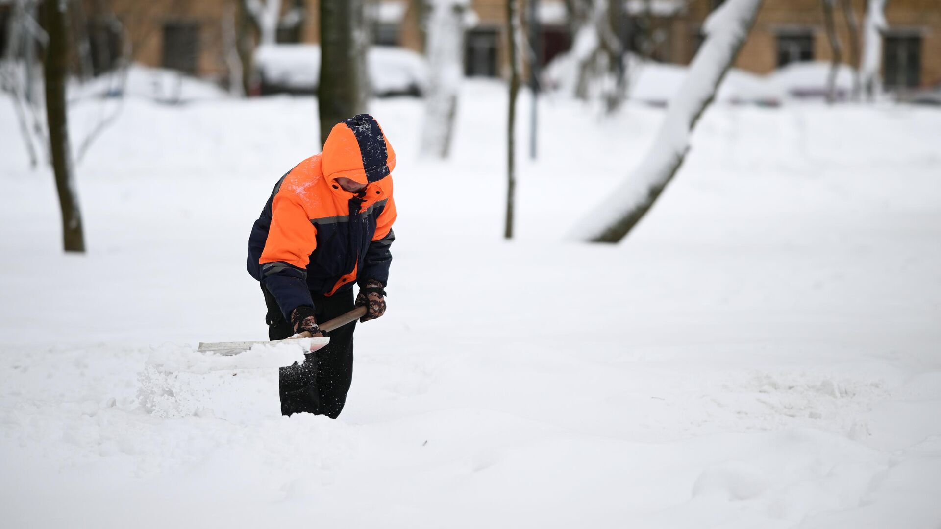 Сотрудник коммунальной службы убирает снег на улице в Москве - РИА Новости, 1920, 16.01.2024