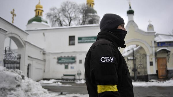 Сотрудник Службы безопасности Украины (СБУ) перед входом в Киево-Печерскую лавру в Киеве