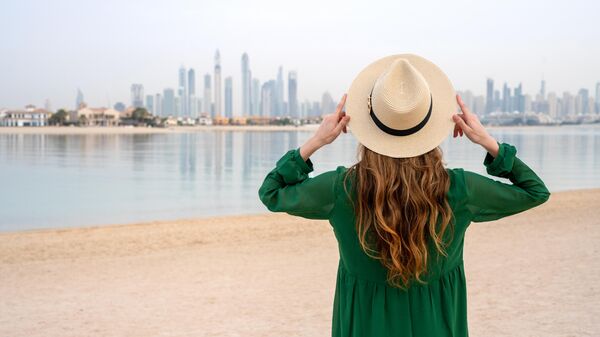 Женщина на пляже с видом на Дубай