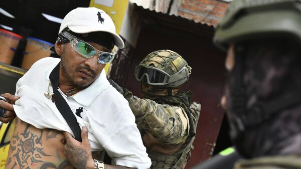 Солдаты осматривает мужчину на наличие бандитских татуировок во время рейда по безопасности в Портовьехо, Эквадор