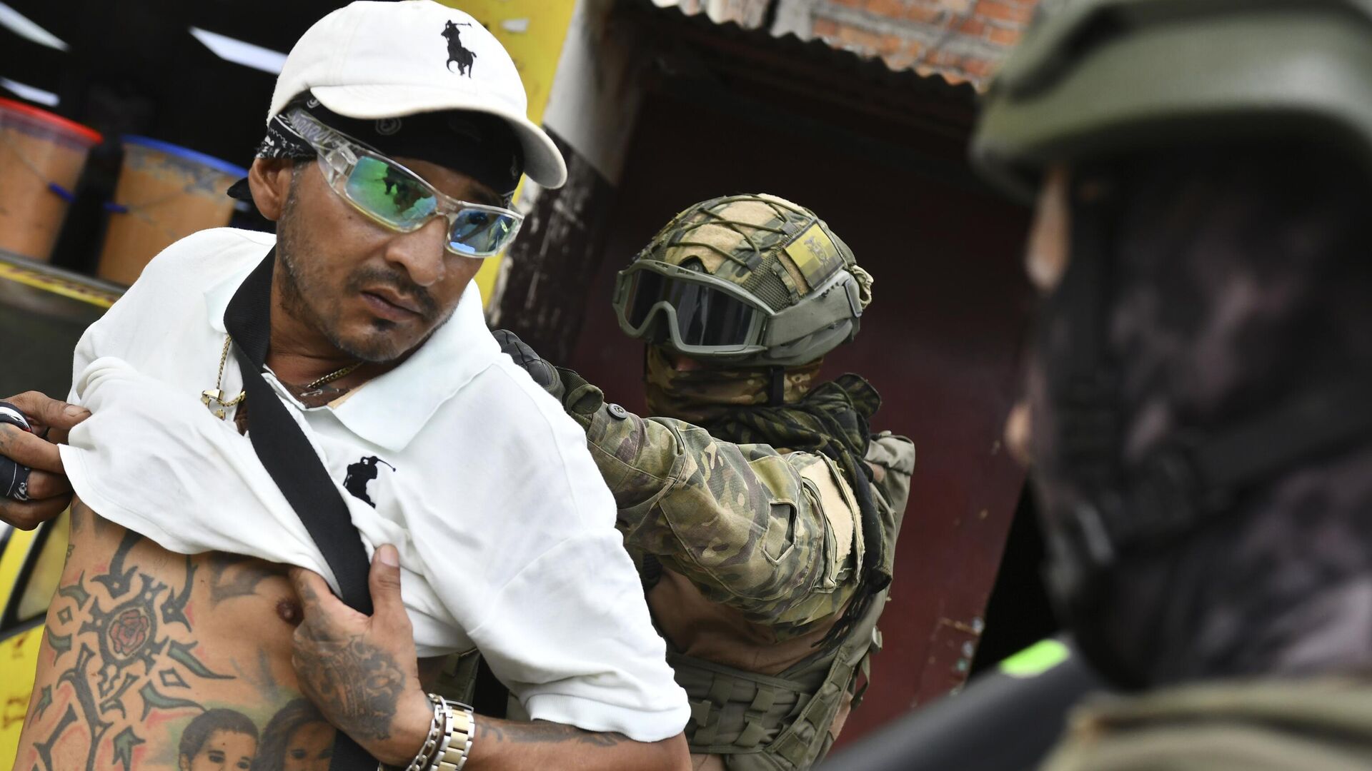 Солдаты осматривает мужчину на наличие бандитских татуировок во время рейда по безопасности в Портовьехо, Эквадор - РИА Новости, 1920, 17.01.2024