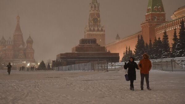 Люди на Красной площади во время снегопада в Москве