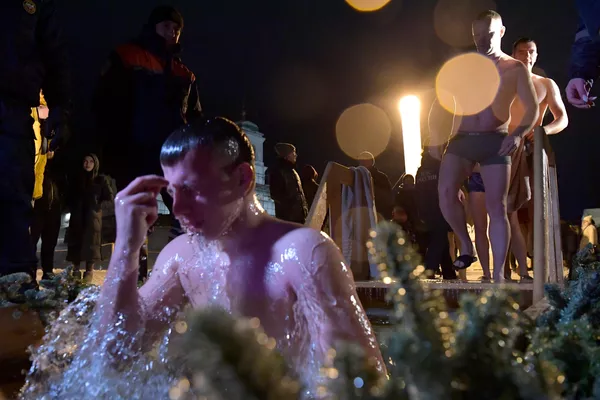プスコフのミロシスキー修道院のヴェリカヤ川で沐浴する公現祭の信者たち