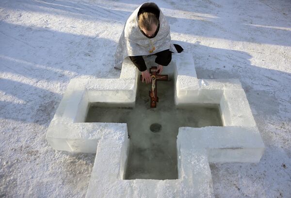 Священнослужитель совершает обряд освящения воды во время крещенских купаний в городе Бердск Новосибирской области