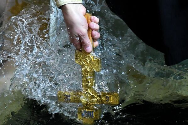 Священнослужитель совершает обряд освящения воды в праздник Крещения во Владивостоке