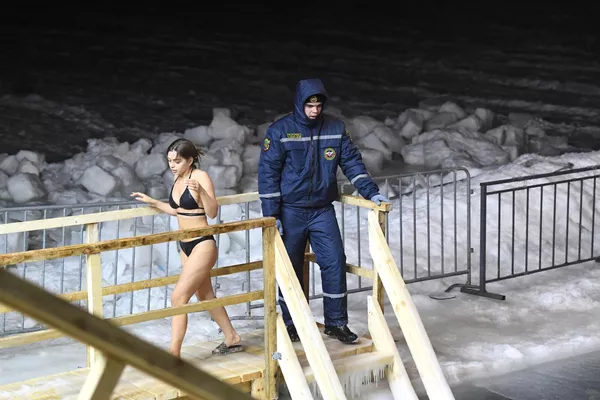ウラジオストクのスポルティヴナヤ港で公現祭の際に水浴びをする少女とライフガード