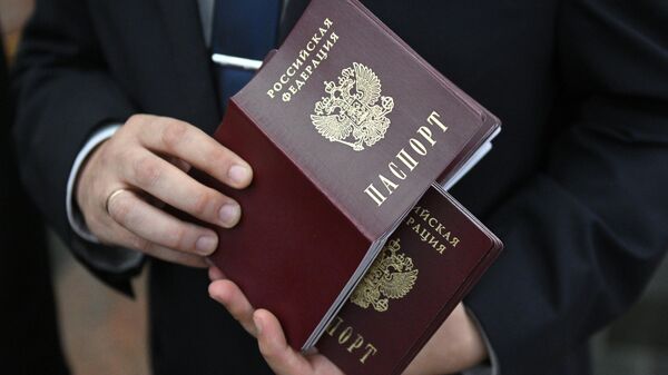 Чиновник держит в руках стопку паспортов