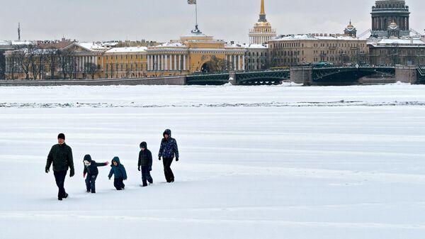 Семья с детьми идет по льду реки Невы в Санкт-Петербурге