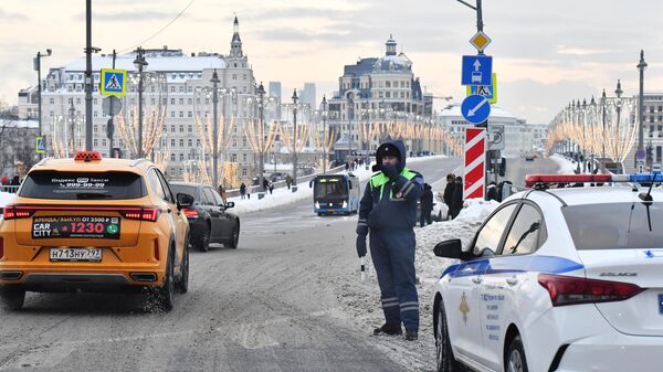 Сотрудник ДПС наблюдают за движением на дороге в Москве