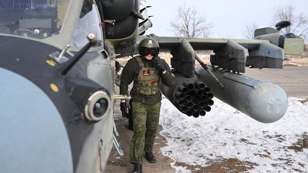 Военнослужащий ВС РФ подготавливает вертолет Ка-52 к вылету для выполнения боевых задач в зоне СВО