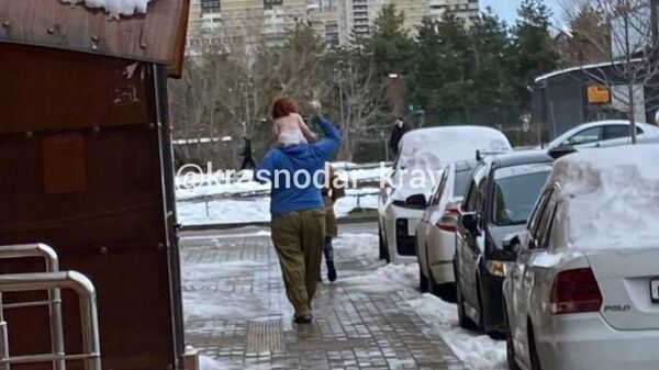 Мужчина с ребенком в подгузнике на улице Краснодара