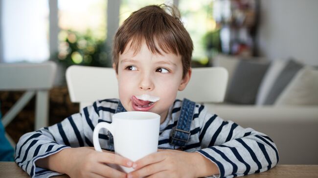 Мальчик пьет молоко