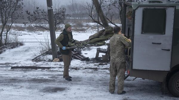 Украинские военнослужащие переносят носилки с раненным в Донецкой области