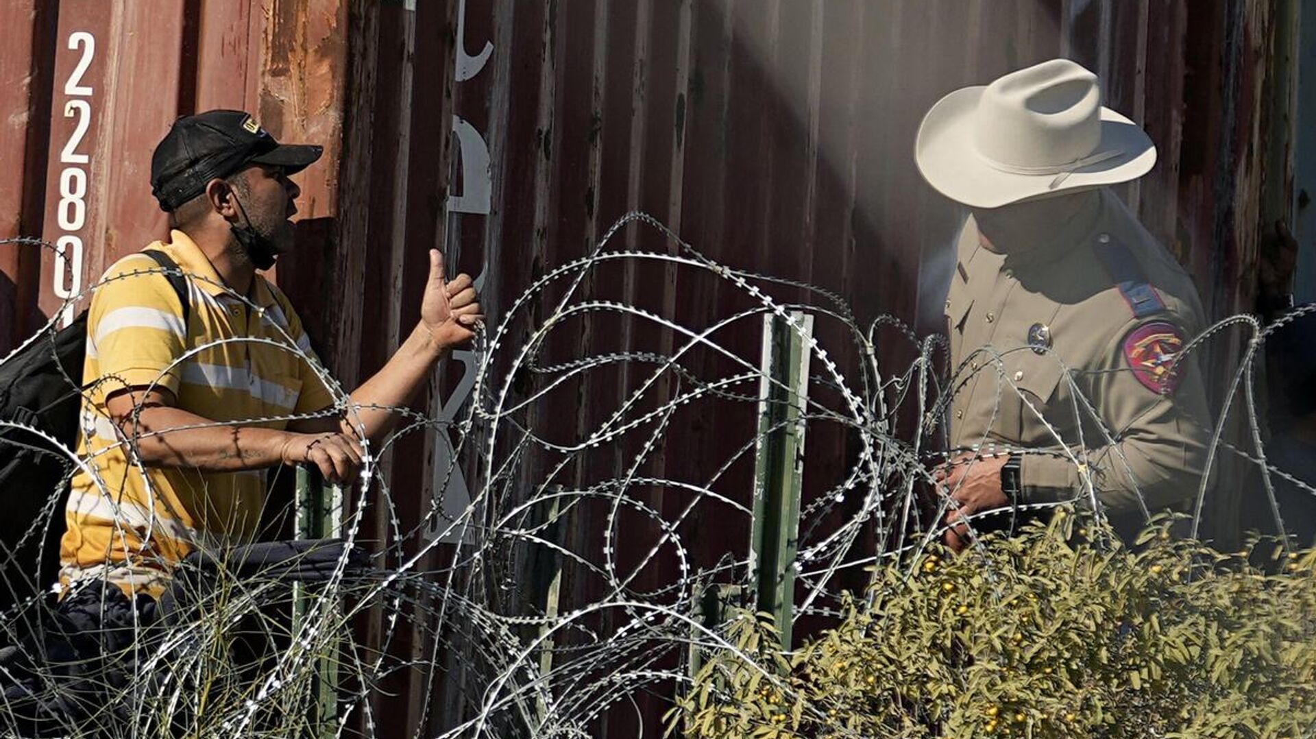 Сотрудник департамента общественной безопасности штата Техас наблюдает за мигрантами из-за колючей проволоки на границе Техаса с Мексикой - РИА Новости, 1920, 04.02.2024