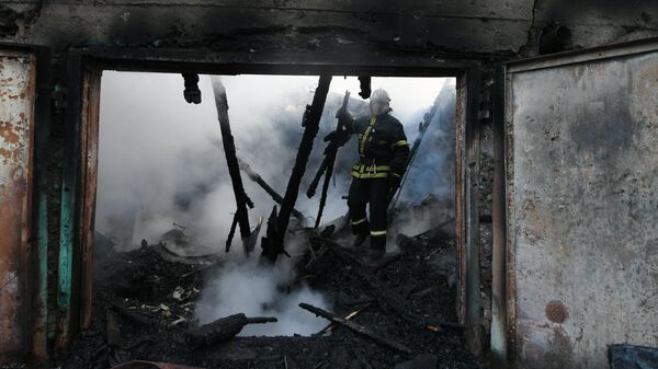 Пожарные на месте сгоревшего в результате попадания снаряда ВСУ частного дома в Донецке около шахты имени Калинина