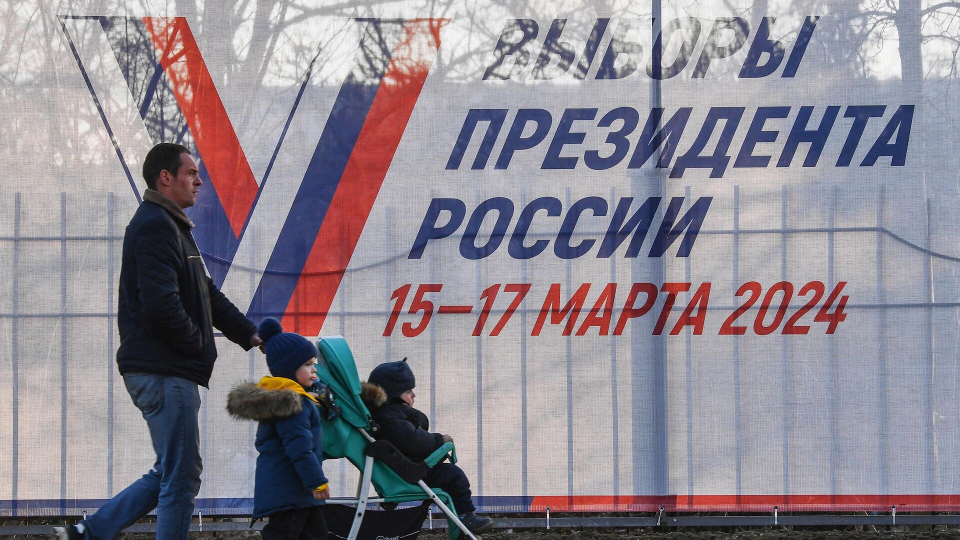 Мужчина с детьми у предвыборного плаката   - РИА Новости, 1920, 05.02.2024