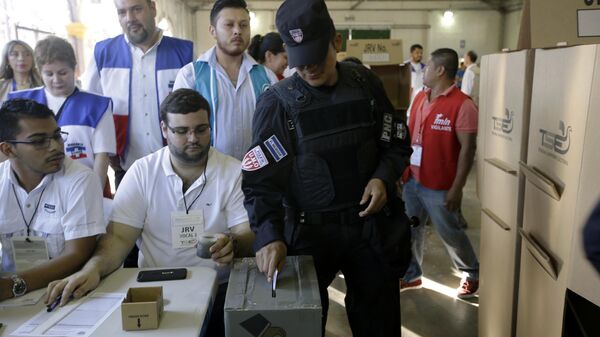 Сотрудник Национального полицейского управления отдает свой голос во время президентских выборов на избирательном участке в Сан-Сальвадоре, Сальвадор