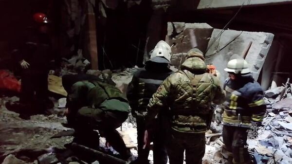 Сотрудники МЧС России из-под завалов извлекают тела погибших в Лисичанске