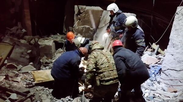 Сотрудники МЧС России из-под завалов извлекают тела погибших в Лисичанске
