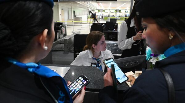 Сотрудницы авиакомпании Jazeera Airways у стойки регистрации в международном аэропорту Домодедово имени М. В. Ломоносова