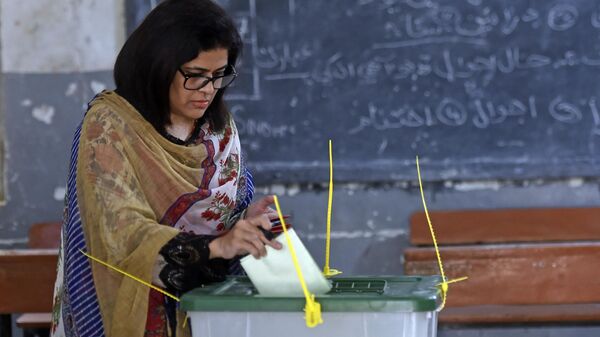 Избирательница отдает свой бюллетень на избирательном участке во время дополнительных выборов в Национальную ассамблею в Карачи