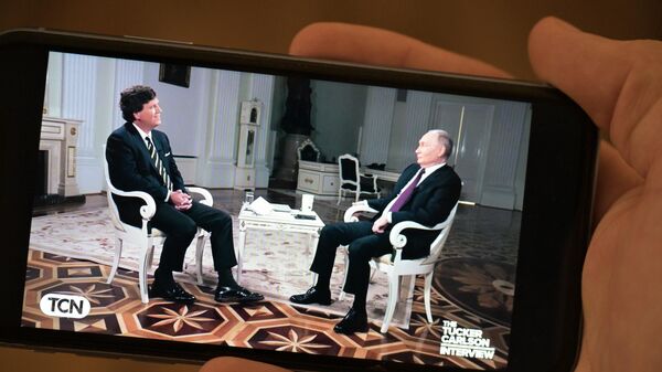 Трансляция интервью Владимира Путина  американскому журналисту Такеру Карлсону на экране телефона