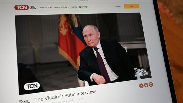 Трансляция интервью резидента РФ Владимира Путина американскому журналисту Такеру Карлсону на экране компьютера