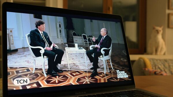 Трансляция интервью президента РФ Владимира Путина американскому журналисту Такеру Карлсону на экране компьютера