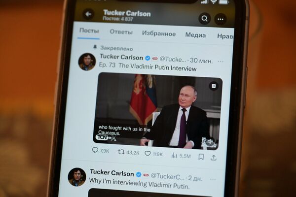 Трансляция интервью президента России Владимира Путина американскому журналисту Такеру Карлсону на экране телефона