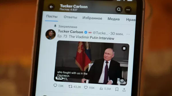 Трансляция интервью президента РФ Владимира Путина американскому журналисту Такеру Карлсону на экране телефона Трансляция интервью президента РФ Владимира Путина американскому журналисту Такеру Карлсону на экране телефона