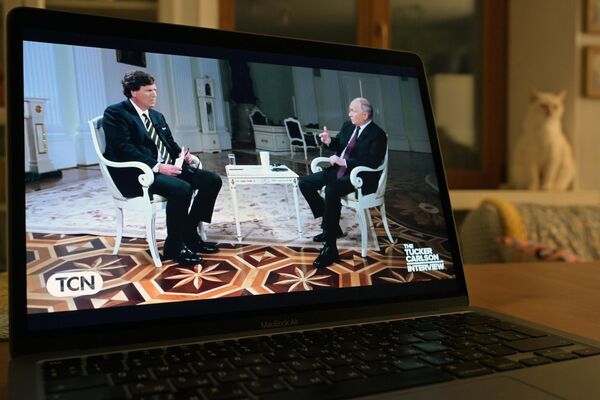 Трансляция интервью президента РФ Владимира Путина американскому журналисту Такеру Карлсону на экране компьютера