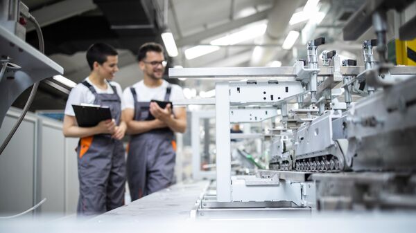 Работники производственной линии контролируют производственный процесс