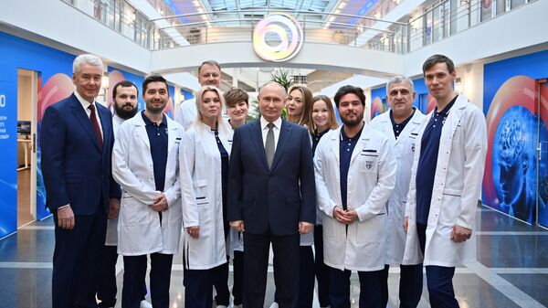 Президент РФ Владимир Путин фотографируется с медицинскими работниками во время посещения ГБУЗ Научно-практический клинический центр диагностики и телемедицинских технологий Департамента здравоохранения города Москвы