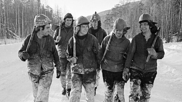 Члены бригады лесорубов, работающей на строительстве БАМа, идут по зимней дороге