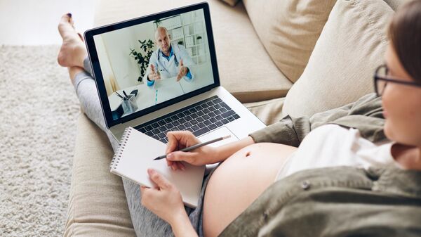 Беременная женщина во время онлайн-консультации с врачом 