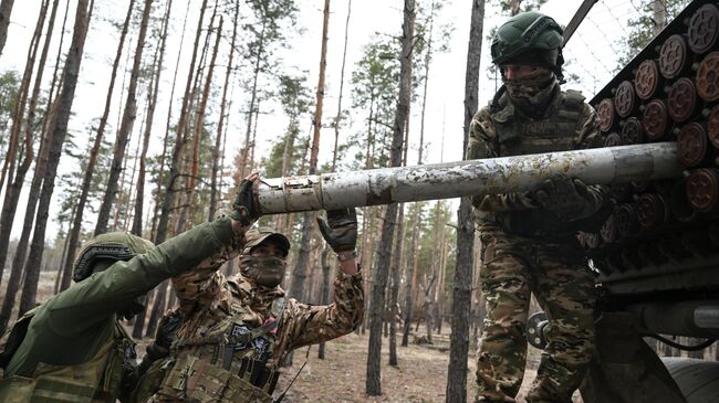 Военнослужащие ВС России загружают РСЗО БМ-21 Град