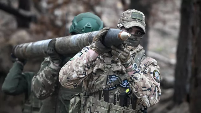 Военнослужащие ВС РФ переносят снаряд для РСЗО БМ-21 Град
