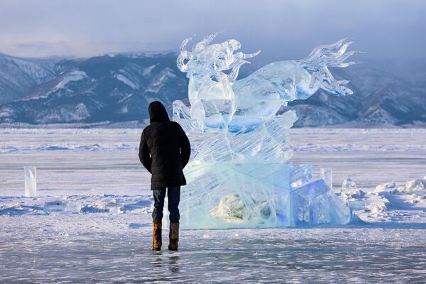 Посетитель на фестивале ледовых скульптур Olkhon Ice Park, проходящем на береговой линии озера Байкал на острове Ольхон